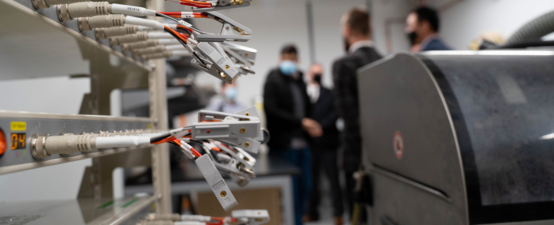 Battery testing facility with out of focus researchers standing in the background